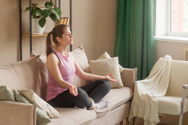 una joven de 20 a 25 años hace yoga en casa. - sitting upright fotografías e imágenes de stock