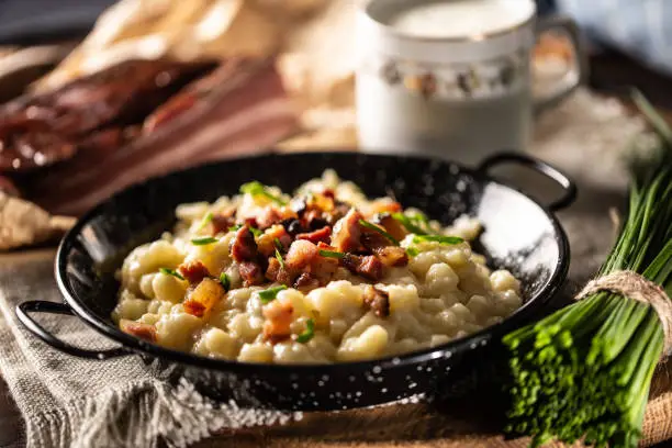 Halusky as traditional Slovak potato gnocchi with sheep cheese bryndza, fried bacon and chives.