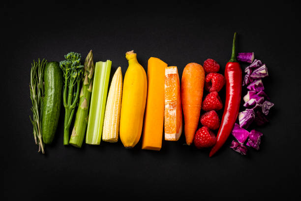 istock Rainbow colored vegetable and fruits sticks on white background 1318251968