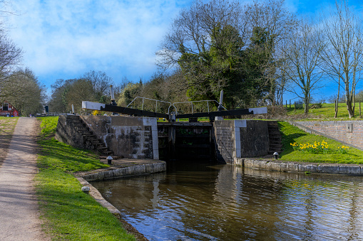 Grand Union Canal at Hatton Locks Warwickshire England UK. It is a sunny spring day and the canal is still. Autumn colours line the bank.