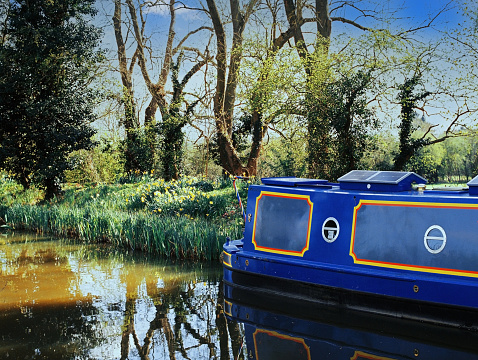 Picturesque landscape of a narrow boat moored on the Avon river awaiting tourists to cruise down the river through Stratford upon Avon, England