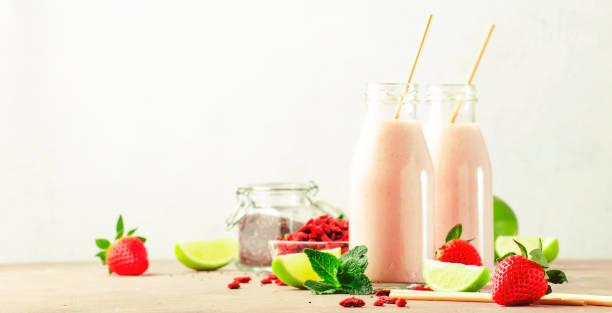 healthy blended diet smoothie drink with strawberry and goji berries, chia seeds and lime. glass bottles with eco fendley straws - vitality food food and drink berry fruit imagens e fotografias de stock