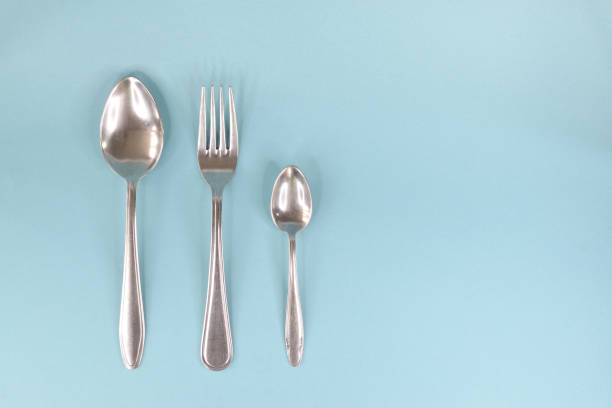 istock A table spoon, fork and teaspoon, laid out in a row on a light background. 1318265482