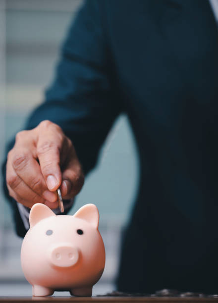 istock Vertical of business man hand putting coins 1318268079
