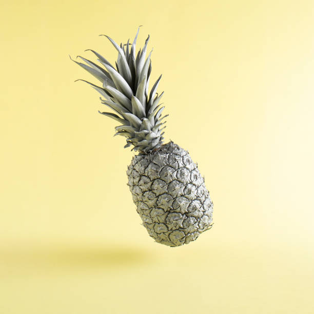 istock The gray pineapple levitates above the yellow background. Minimal style. Creative summer or food concept. 1318269401