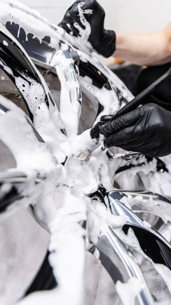 istock Car detailing studio worker cleaning luxury car wheel 1318273697
