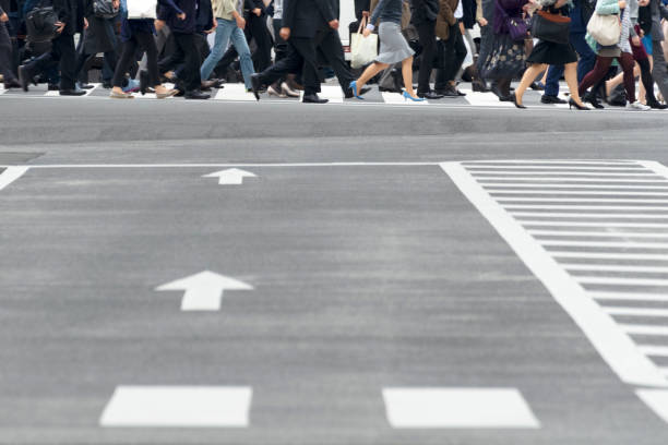 istock People working in a business district crossing a pedestrian crossing. 1318277348