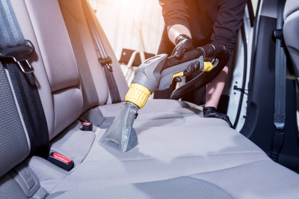 istock Worker cleans car interior with vacuum cleaner 1318283220