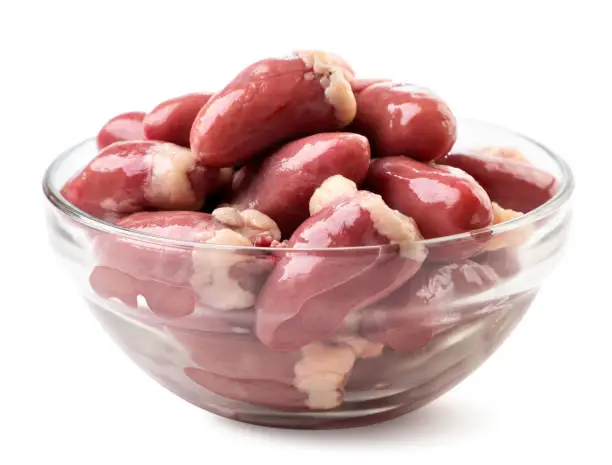 Raw chicken hearts in a glass plate close-up on a white background. Isolated