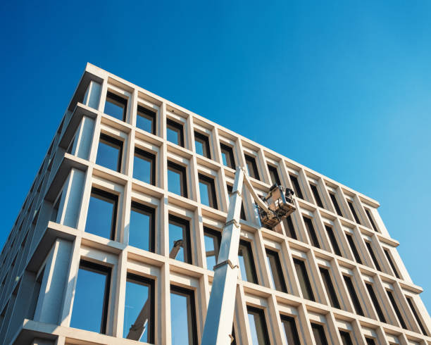 Workers are cleaning windows of a facade from a boom lift.