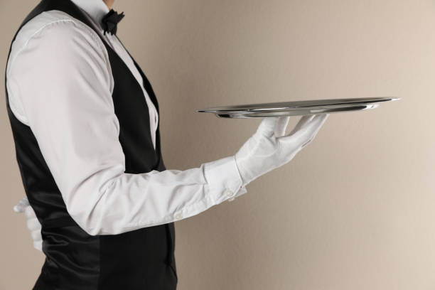 istock Butler with tray on beige background, closeup 1318289222