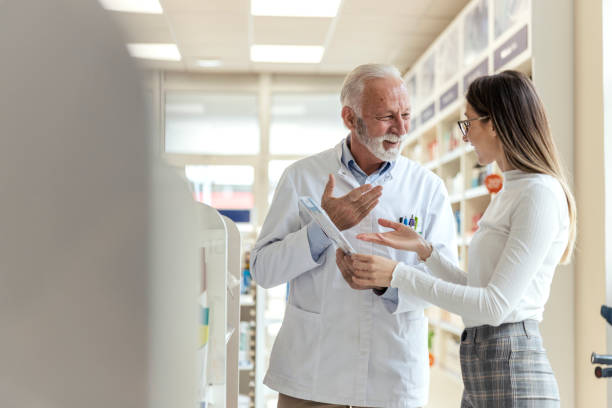istock Consultation with a professional, conversation between the pharmacist and the client. A mature man explains drug therapy to a client. An experienced pharmacist recommends therapy to the client 1318289369