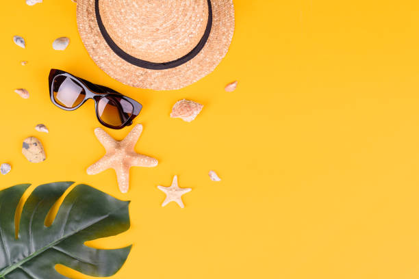 istock Beach accessories: glasses and hat with shells and sea stars on a colored background 1318289432