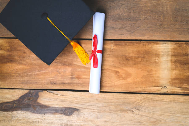 istock Black Graduation Hat and Certificate placed on Old wood background 1318289489