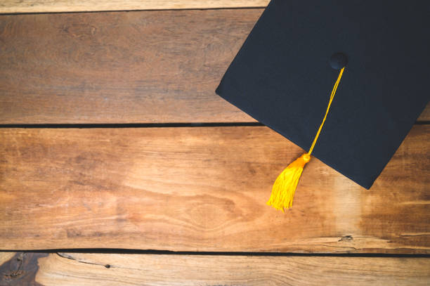 istock Black Graduation Hat placed on Old wood background 1318289525