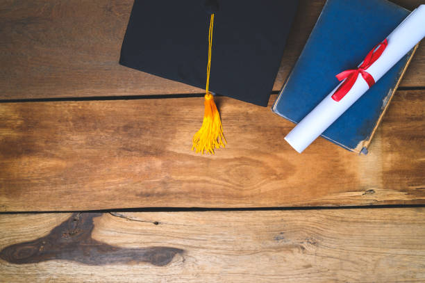istock Black Graduation Hat and Certificate placed on Old wood background 1318290040