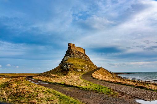 Rural fence leads up to Lindisfarne Castle on the Holy Island of Lindisfarne.