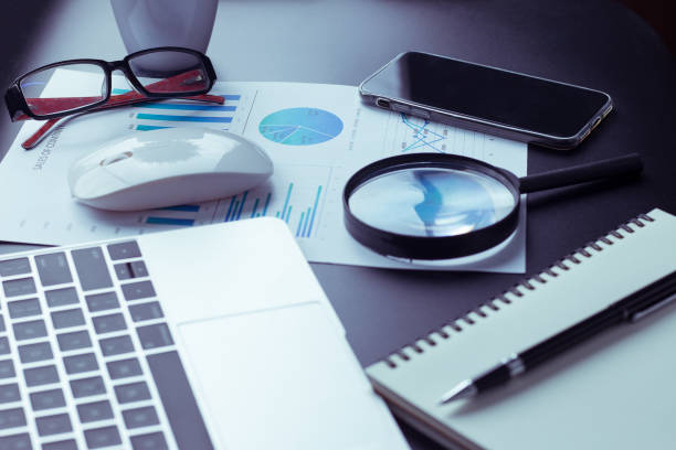 istock A desk, a black desk with a computer, a graph, a magnifying glass, and a calculator. 1318295120