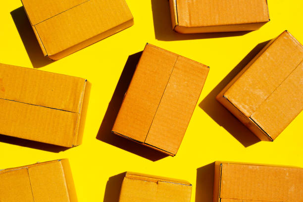 istock Brown cardboard boxes on yellow background. 1318299408