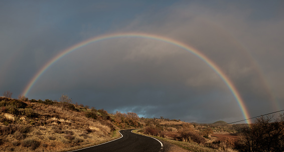 Panoramic view of rainbow over road against sky.