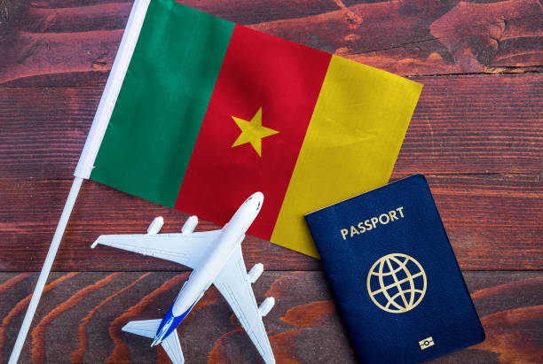 Flag of Cameroon with passport and toy airplane on wooden background. Flight travel concept. cameroon stock pictures, royalty-free photos & images
