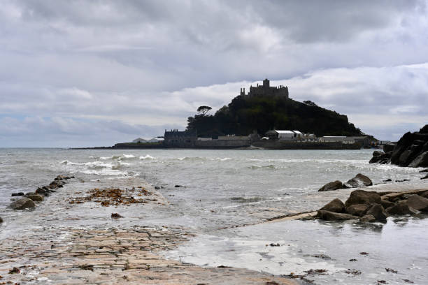 istock Saint Michael's Mount in Cornwall showing the unique tidal path being covered by the incoming tide,  tidal island in Mount's Bay, Cornwall, United Kingdom. 1318303754