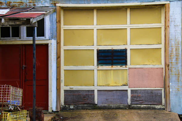 istock old abandoned warehouse building structure garage door with yellow pink red and blue highlight colors faded over time as an rural architectural scene 1318304316