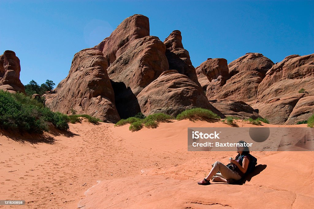 Hiker Resting Hiker taking a break to enjoy the scenery at Arches National Park in Utah. Adult Stock Photo