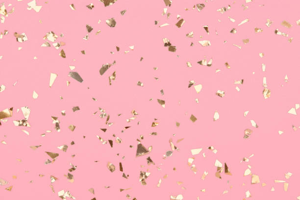 istock Golden confetti on pastel pink background, party gold glitter backdrop. 1318314018