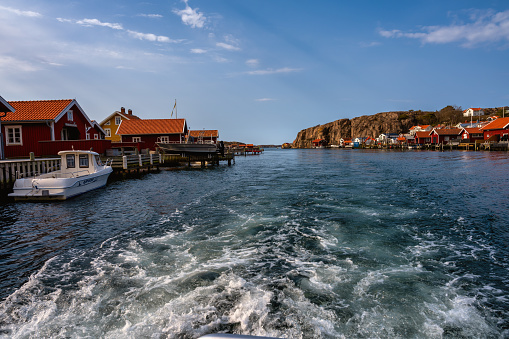April 17, 2021 - Hamburgsund, Sweden: A picturesque fishing village on the Swedish West coast. Traditional red sea huts and a blue sky in the background