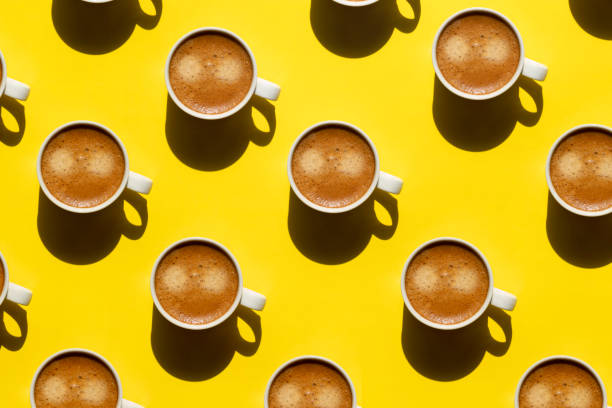 istock Pattern made of cup of cappuccino on yellow background 1318319353
