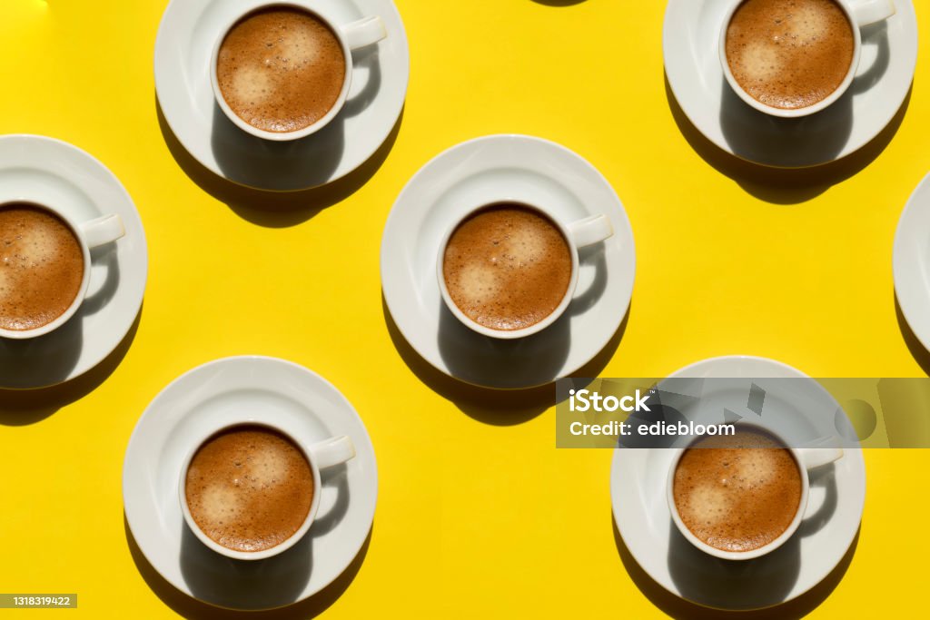 Pattern made of cup of cappuccino on yellow background Coffee - Drink Stock Photo