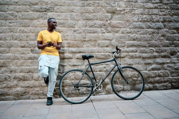 istock young black man using his smartphone with bike 1318321209