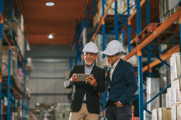 istock asian chinese management having discussion at warehouse with white hardhat using digital tablet 1318322395