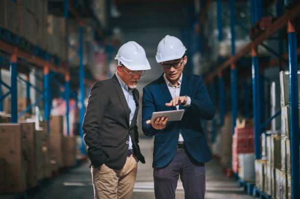 istock asian chinese management having discussion at warehouse with white hardhat using digital tablet 1318322412