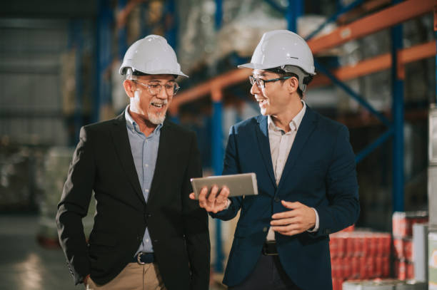 istock asian chinese management having discussion at warehouse with white hardhat using digital tablet 1318322430