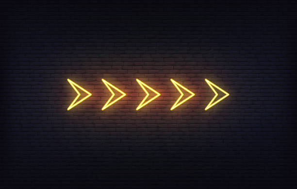 istock Neon arrow sign. Set of orange glowing neon arrow pointer on brick wall background. 1318322543