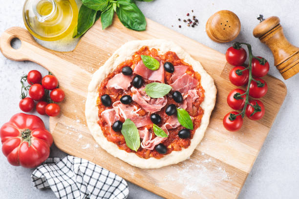 pizza crudo con salsa di pomodoro, prosciutto e olive - tomato sauce domestic kitchen meat cheese foto e immagini stock