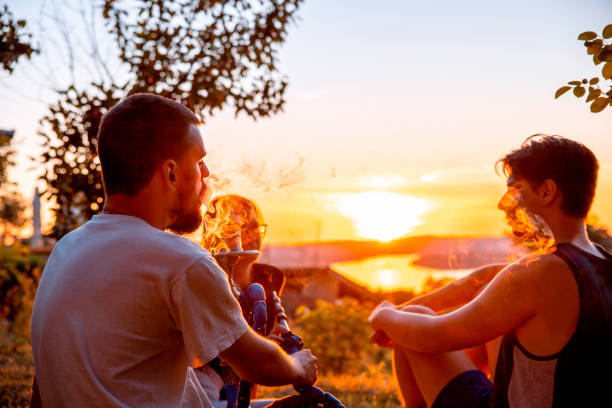 Smoking Shisha Hookah on sunset outdoors Friends smoking Shisha Hookah on sunset over the river hookah friends stock pictures, royalty-free photos & images