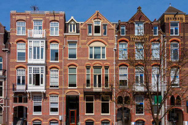 涼しい春の朝の晴れた空の下で、私たちはアムステルダムの特徴である建築の多様性を見ます - brick european culture facade famous place ストックフォトと画像
