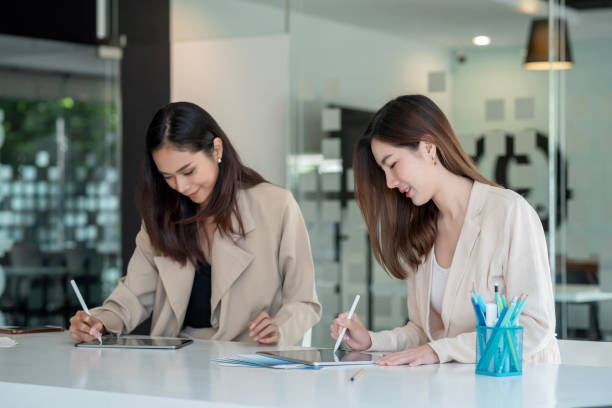 istock Two young asian businesswoman help to analyze the working using a tablet at the office. 1318327556