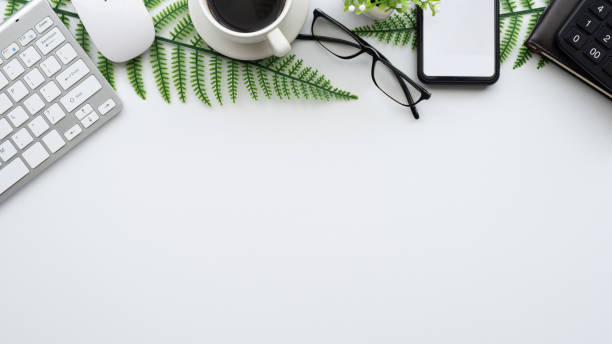 istock White office desk. table with blank notebook, tablet, computer and other office supplies. Top view with copy space. 1318327651