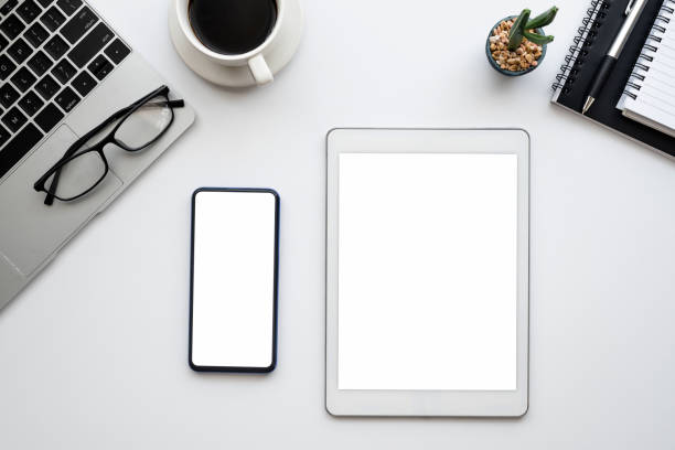 istock Top view tablet and smartphone  blank white screen on the workbench at office. Mock up. 1318327728