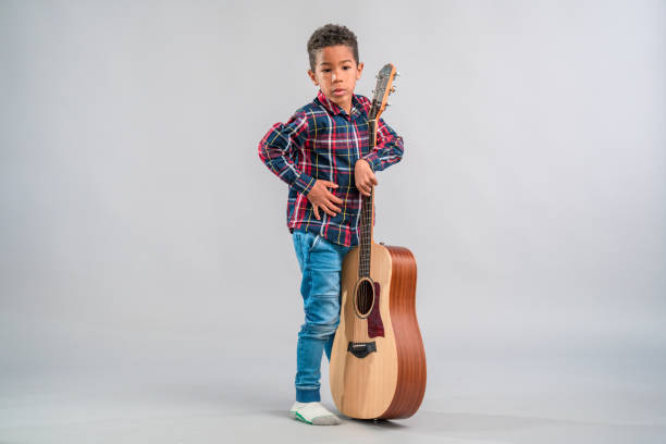 istock Mixed Race Child Holding a Guitar 1318330982