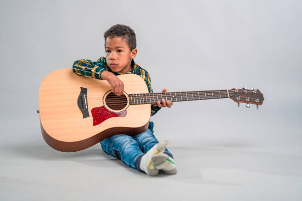 istock Mixed Race Child Holding a Guitar 1318331000