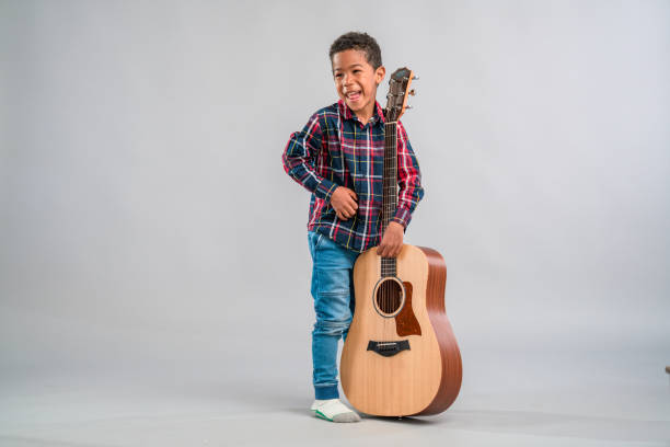 istock Mixed Race Child Holding a Guitar 1318331019