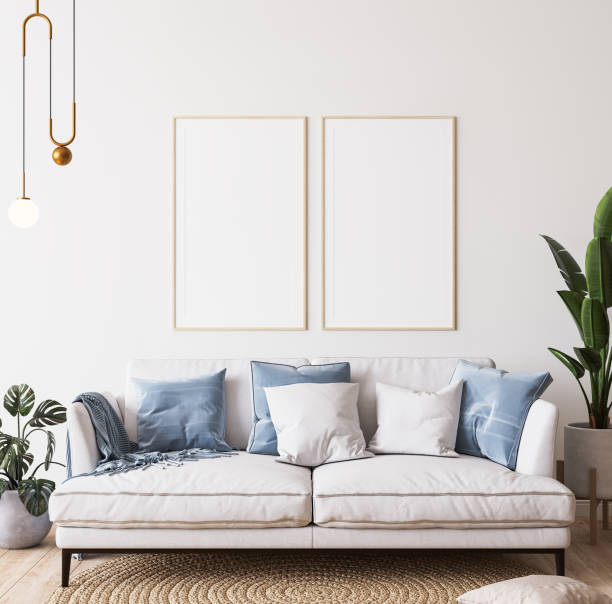 밝은 현대식 객실의 포스터 모형, 파란색 쿠션이 있는 흰색 소파, 최소한의 배경에 녹색 식물 - cushion sofa pillow indoors 뉴스 사진 이미지