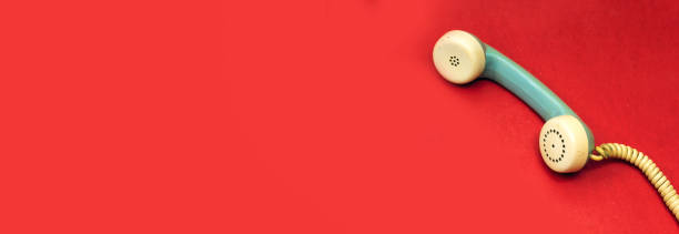 istock old handset phone isolated on red background 1318333446