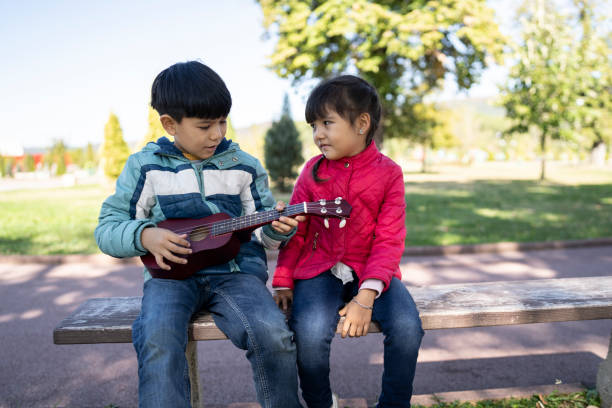 istock A boy playing a toy guitar while his sister watches him 1318334460