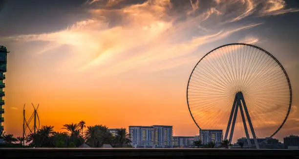 Sunset on Bluewaters Island, with the famous Ain Dubai Ferris wheel under construction, with shot point from Marina Beach Perfect shot for sunsets, travel, vacations and vacations.